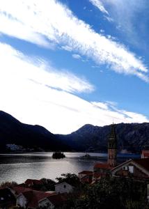 a view of a large body of water with a clock tower at Apartment Mediterraneo Blue Sky in Perast
