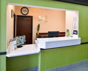 une salle d'attente avec une horloge sur un mur vert dans l'établissement Econo Lodge Inn & Suites, à Shelbyville