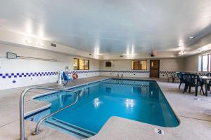 a large swimming pool in a room with tables and chairs at Quality Inn & Suites La Vergne in La Vergne
