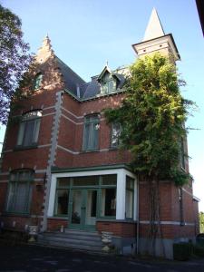 un edificio de ladrillo rojo con un árbol delante de él en B&B Fine Fleur en Bruges