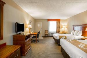Hurricane MillsにあるQuality Inn Hurricane Millsのベッド2台、薄型テレビが備わるホテルルームです。