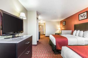 a hotel room with two beds and a flat screen tv at Quality Inn & Suites in La Vergne