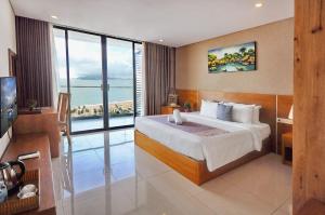 - une chambre avec un grand lit et une grande fenêtre dans l'établissement Holi Beach Hotel & Apartments, à Nha Trang