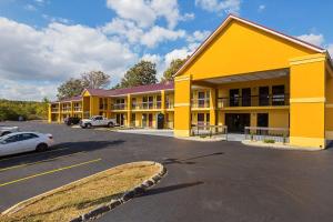 um grande edifício amarelo com carros estacionados num parque de estacionamento em Motel 6 Knoxville, Tn - East em Knoxville