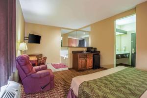 a hotel room with a bed and a chair at Econo Lodge Inn & Suites in Ripley +23 photos