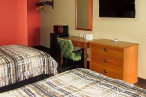 una camera d'albergo con letto, scrivania e letto gmaxwell gmaxwell gmaxwell xwell di Rodeway Inn Murfreesboro Downtown a Murfreesboro