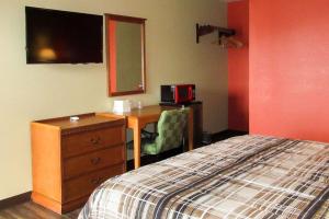 una camera da letto con una scrivania, un letto e una cassettiera di Rodeway Inn Murfreesboro Downtown a Murfreesboro
