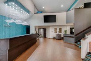 un vestíbulo de oficina con recepción y TV de pantalla plana en Clarion Inn & Suites DFW North, en Irving