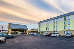 a parking lot with cars parked in front of a building at Clarion Inn & Suites near Downtown in Knoxville