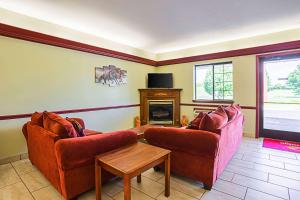 a living room with two chairs and a fireplace at Econo Lodge Inn & Suites Ripley in Ripley