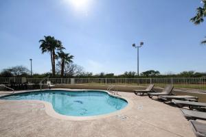 a swimming pool with lounge chairs and a volley ball court at Quality Inn Kingsville Hwy 77 in Kingsville
