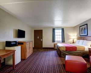 a hotel room with a large bed and a desk at Rodeway Inn New Braunfels in New Braunfels