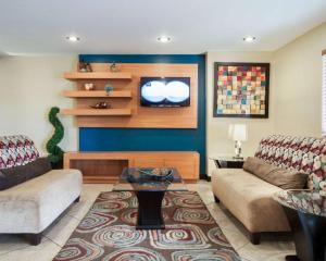 uma sala de estar com dois sofás e uma televisão em Quality Inn Airport East em El Paso