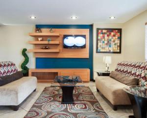 a living room with two couches and a tv at Quality Inn Airport East in El Paso