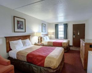 a hotel room with two beds and a television at Rodeway Inn New Braunfels in New Braunfels