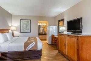 a hotel room with a bed and a flat screen tv at Quality Inn Pasadena Houston in Pasadena