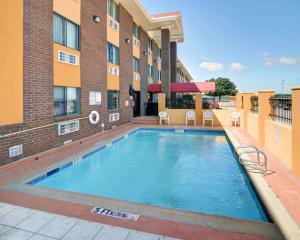 a swimming pool in front of a building at Quality Inn DFW Airport North in Irving
