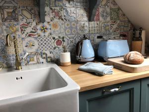 eine Küche mit einer Spüle und einer Küchentheke mit Fliesen in der Unterkunft GRIMM'S LIVING in Kassel