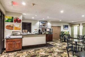 a restaurant with a counter and tables and chairs at Quality Suites, Ft Worth Burleson in Burleson