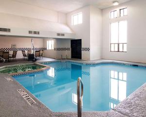 a large swimming pool with blue water in a building at Quality Inn Midland in Midland