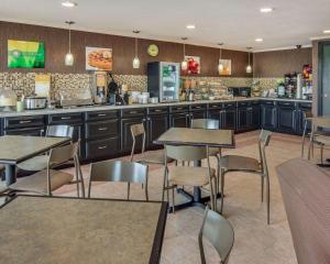 um restaurante com mesas e cadeiras e uma cozinha em Quality Inn Mt. Pleasant em Mount Pleasant