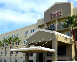 a hotel room with a large white building behind it at Comfort Suites Beachside in South Padre Island