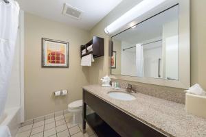 a bathroom with a sink, mirror, and toilet at Comfort Suites Beachside in South Padre Island