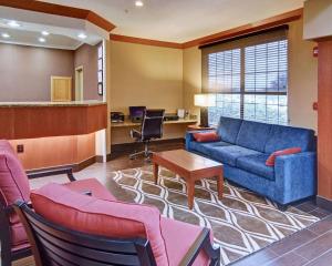 ein Wohnzimmer mit einem blauen Sofa und Stühlen in der Unterkunft Comfort Suites Roanoke - Fort Worth North in Roanoke