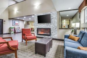 Comfort Inn & Suites Love Field-Dallas Market Center في دالاس: غرفة معيشة مع أريكة ومدفأة