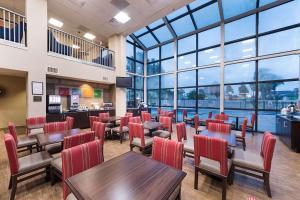 a restaurant with tables and chairs and large windows at Comfort Suites Beachside in South Padre Island
