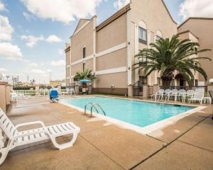 una piscina con sillas y un edificio en Comfort Suites Stafford Near Sugarland en Stafford