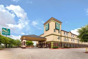 a front view of a hotel with a parking lot at Quality Inn Near Seaworld - Lackland in San Antonio