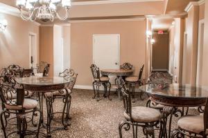 ein Zimmer mit Tischen, Stühlen und einem Kronleuchter in der Unterkunft O'Brien Riverwalk Boutique Hotel in San Antonio