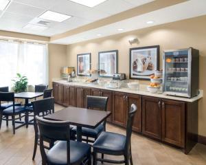 a restaurant with tables and chairs and a counter at Comfort Suites Odessa in Odessa