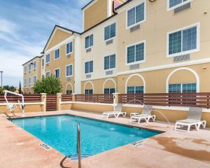 a swimming pool in front of a building at Comfort Suites Odessa near University in Odessa