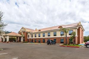a large building with a car parked in a parking lot at Sleep Inn & Suites Stafford - Sugarland in Stafford