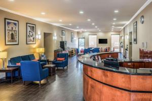 a lobby with a bar and blue chairs at Comfort Suites Near Texas State University in San Marcos