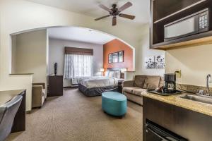 a hotel room with a bed and a kitchen at Sleep Inn & Suites Stafford - Sugarland in Stafford