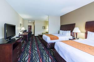 a hotel room with two beds and a flat screen tv at Comfort Suites Beaumont I-10 in Beaumont