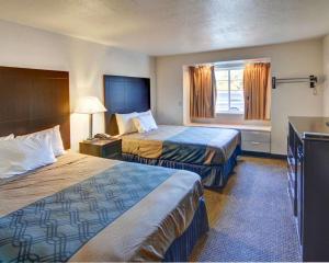 a hotel room with two beds and a window at Rodeway Inn & Suites Lewisville I-35 in Lewisville