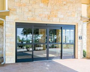 un accès à un bâtiment avec des portes en verre dans l'établissement Sleep Inn & Suites near Palmetto State Park, à Gonzales