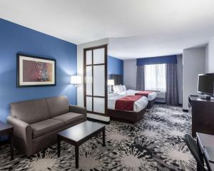 a hotel room with a bed and a couch at Comfort Suites Greenville in Greenville