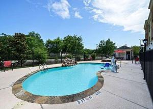 a large swimming pool in a park with at Comfort Suites Bay City in Bay City