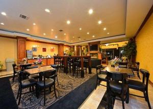 um restaurante com mesas e cadeiras e um bar em Comfort Suites Bay City em Bay City