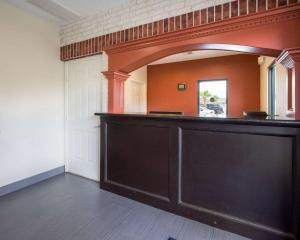 eine große schwarze Bar in einem Zimmer mit orangefarbener Wand in der Unterkunft Scottish Inn & Suites IAH West in Westfield