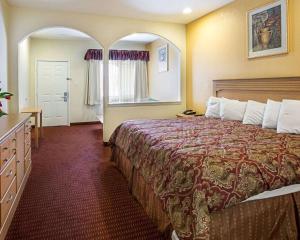a hotel room with a large bed and a window at Scottish Inn & Suites IAH West in Westfield +30 photos