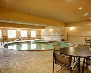 uma grande piscina interior com mesa e cadeiras em Comfort Suites Buda - Austin South em Buda