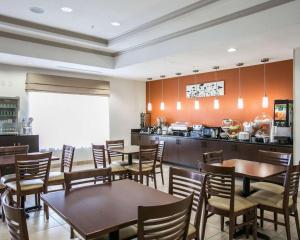 a restaurant with tables and chairs and a kitchen at Restwell Inn & Suites I-45 North in Houston