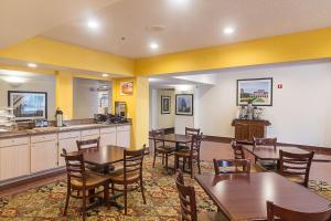 a restaurant with tables and chairs and a kitchen at Quality Inn & Suites West Chase in Houston