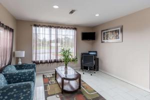 sala de estar con sofá, mesa y TV en Quality Inn & Suites Bridge City Orange, en Bridge City